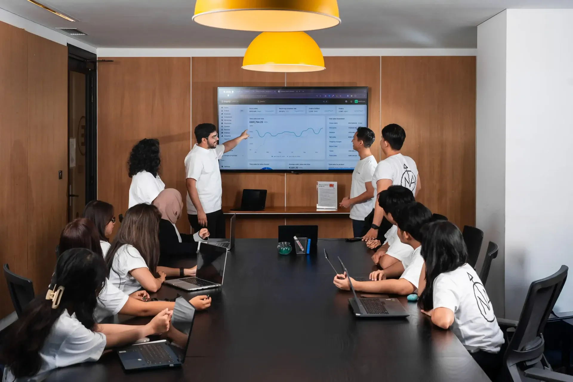 Das NAVEGaid-Team bespricht ein Analytics-Dashboard auf einem Bildschirm im Besprechungsraum